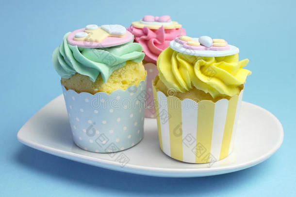 婴儿淋浴或儿童粉色、浅绿色和黄色纸杯蛋糕