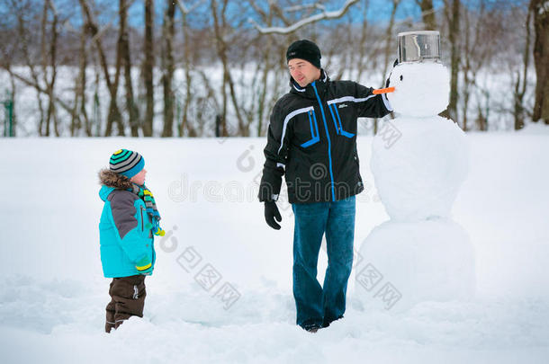 小男孩和他父亲堆雪人