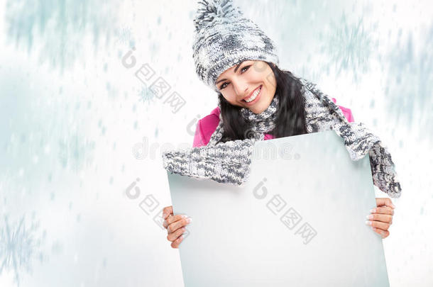一个微笑的女孩，带着一块白板，围着雪