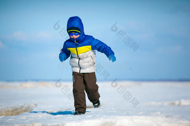 可爱的小男孩在冬日海滩上玩耍