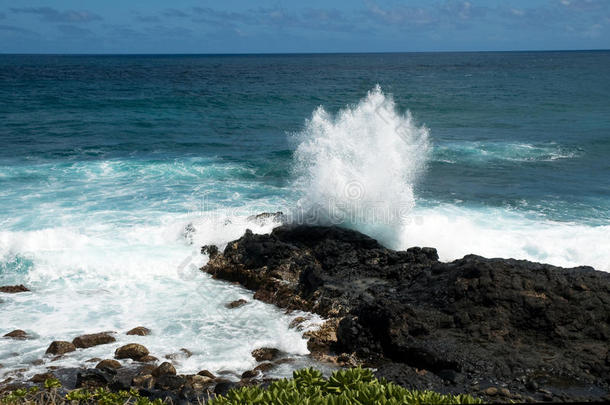 夏威夷黑色熔岩上的波浪