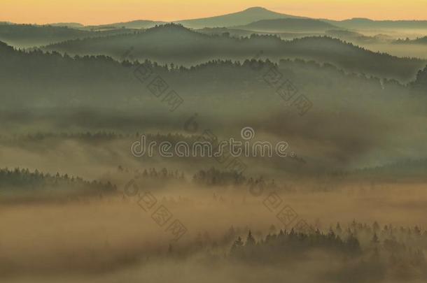 在瑞士撒克逊人的深雾山谷。砂岩山峰从雾状背景增加，雾呈蓝橙色