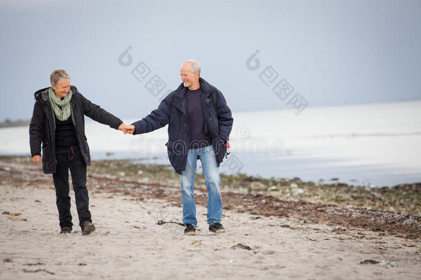 秋日漫步沙滩的成熟幸福夫妻