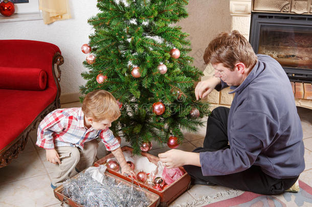 父亲和小儿子在家里装饰圣诞树