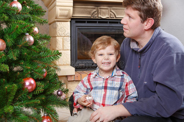 父亲和小儿子在家里装饰圣诞树