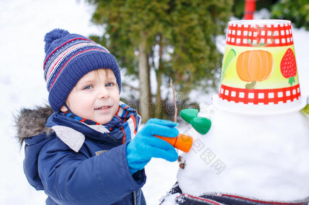 冬日可爱的小男孩玩雪人