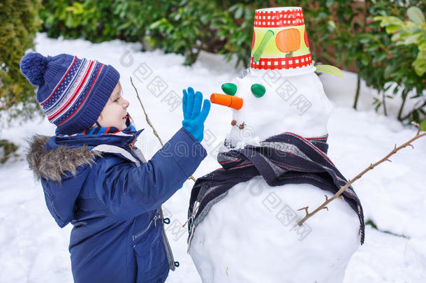 冬日可爱的小男孩玩雪人