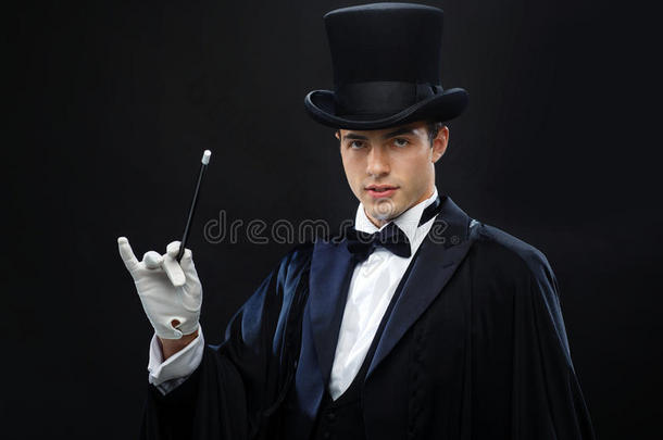 头戴高帽的魔术师用魔杖表演魔术