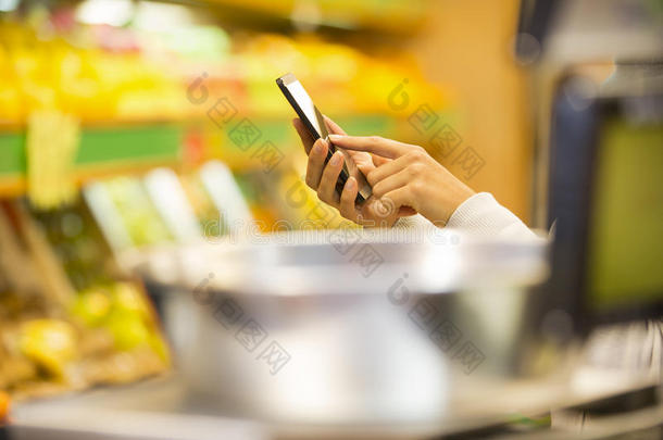 妇女在<strong>超市</strong>购物时使用<strong>手机</strong>