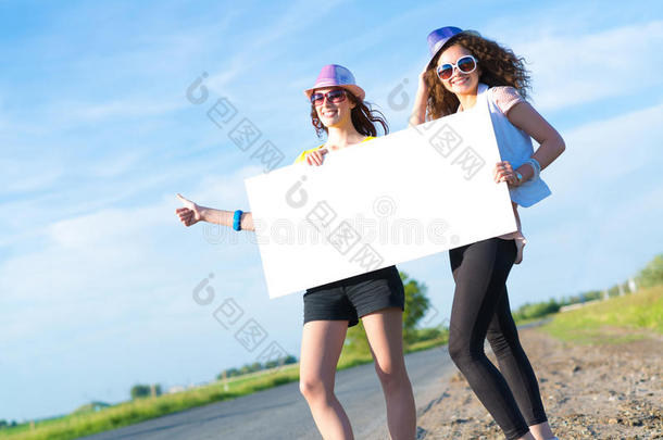 两个年轻女子举着一面空白的横幅站着