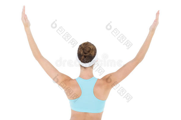身穿运动服的苗条黑发女子举起手臂的后视图