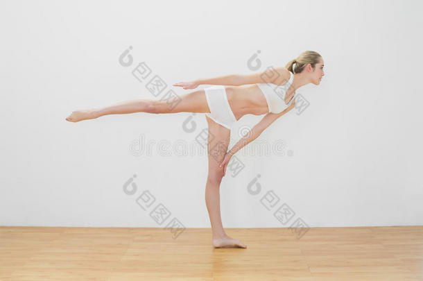 运动型身材的女士穿着运动服做瑜伽姿势