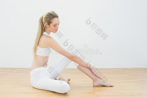 坐在地板上<strong>舒展</strong>双腿的运动型冷静女子