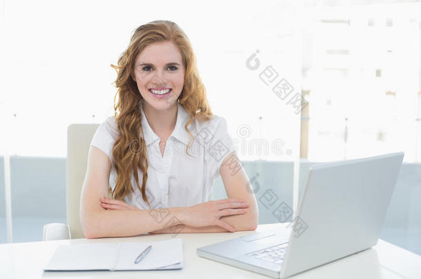 微笑的女商人，办公室里有笔记本电脑
