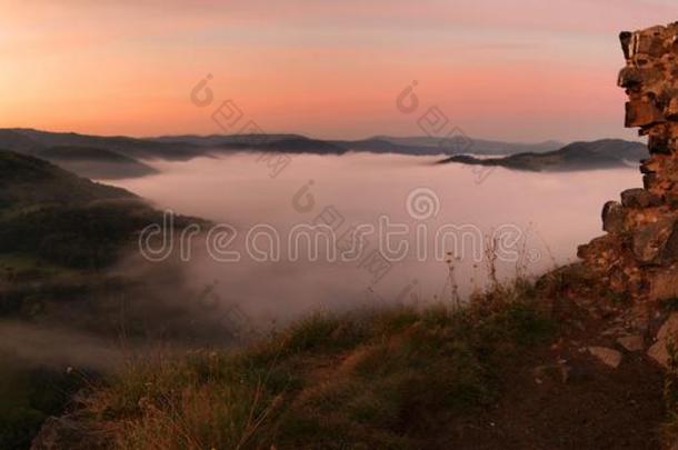 夏日的日出在小山之上，五彩缤纷的天空，五彩缤纷的砂岩岩石。