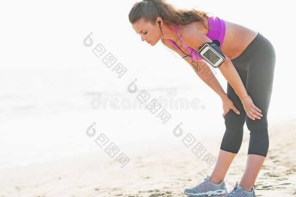 健身女青年在沙滩上跑步后<strong>呼吸困难</strong>
