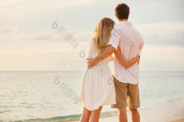 夕阳沙滩上的幸福浪漫情侣