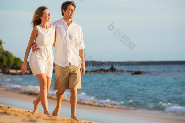 夕阳沙滩上漫步的浪漫幸福夫妻