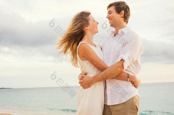 夕阳沙滩上幸福浪漫的情侣相拥