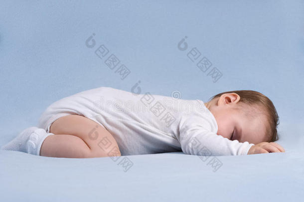 婴儿睡在柔软的蓝色毯子上
