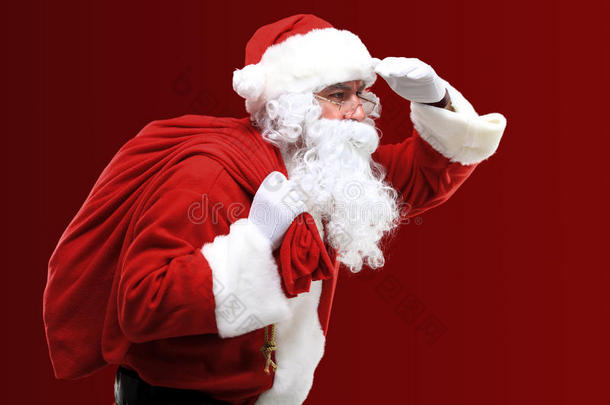 圣诞老人提着一个红色的大袋子，里面装着礼物