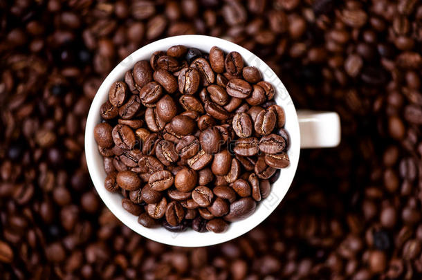 装满咖啡豆和咖啡背景的咖啡杯