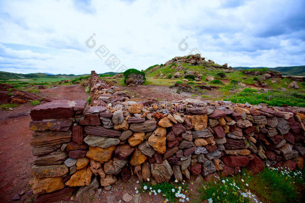 梅诺卡砌石红色石墙，带栅栏门
