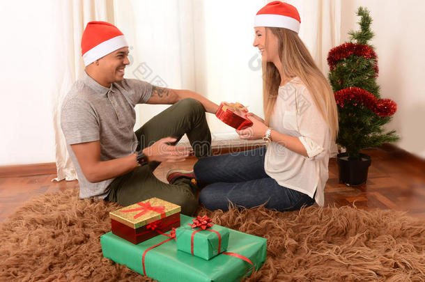圣诞节小情侣在地毯上送礼物