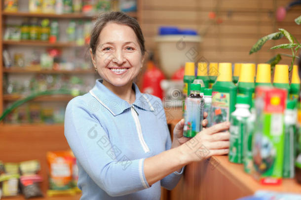 女人在商店里选择农业化学