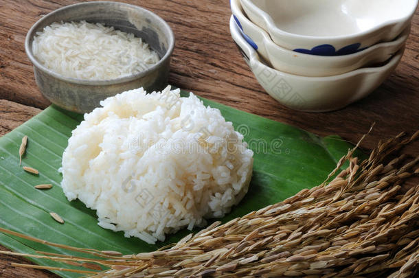 木桌上的米饭、生米和米饭