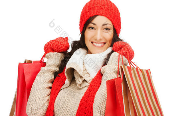 穿着暖和衣服，拎着购物袋的微笑的女人