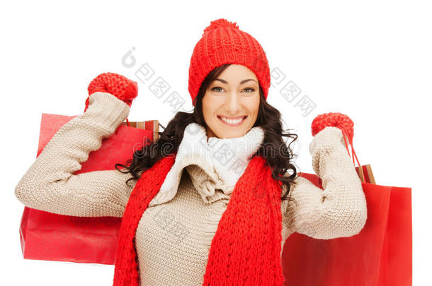 穿着暖和衣服，拎着购物袋的微笑的女人