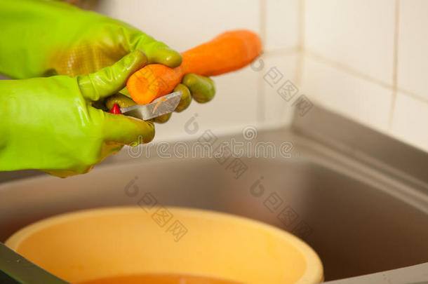 女人在厨房里用手切胡萝卜。健康营养