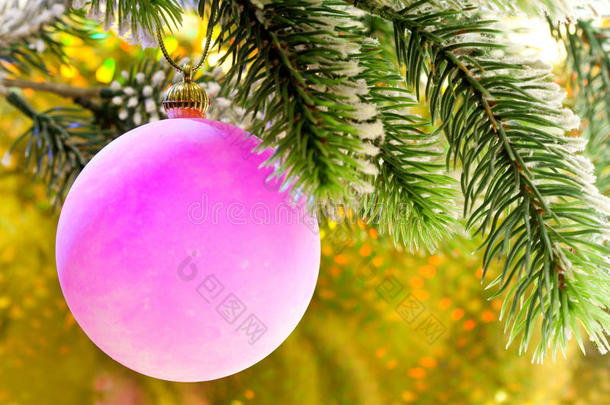 圣诞树枝上的粉红色新年球树。关闭在黄色背景上