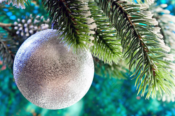 圣诞树枝上美丽的银色新年舞会树。关闭在绿色背景上