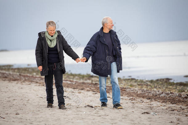 秋日漫步沙滩的成熟幸福夫妻