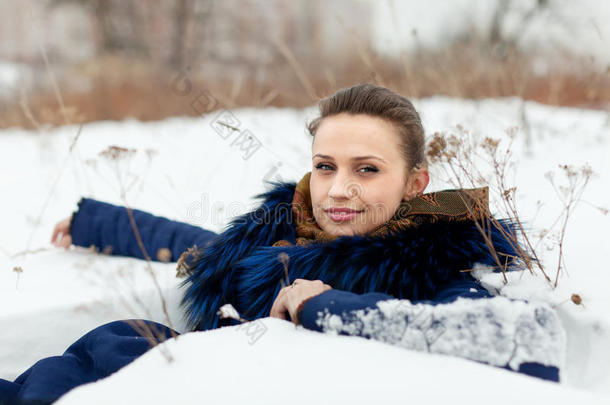 穿大衣的女孩躺在雪地上