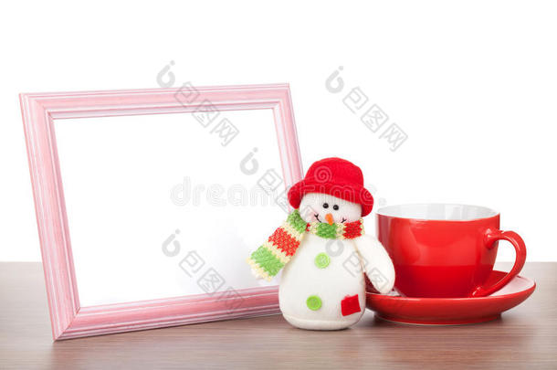 空白相框、圣诞雪人和木制茶杯