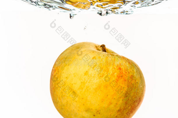 水里的黄苹果溅在白色的上面