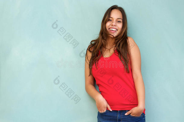 穿着红色衬衫、双手插在口袋里微笑的放松的年轻女子