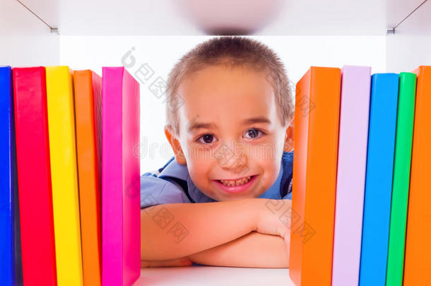小男孩透过书架看