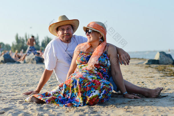 夏日沙滩上坐在海边的成熟情侣户外背景