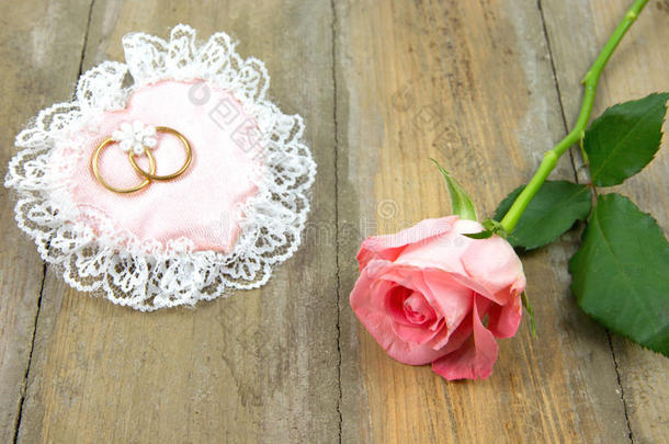 带结婚戒指和玫瑰的棉粉色心形