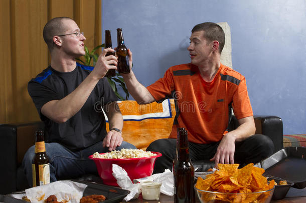 体育迷一边喝啤酒一边在电视上观看体育比赛，水平