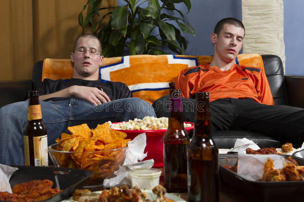 两个疲惫的男人在电视上看了体育比赛后