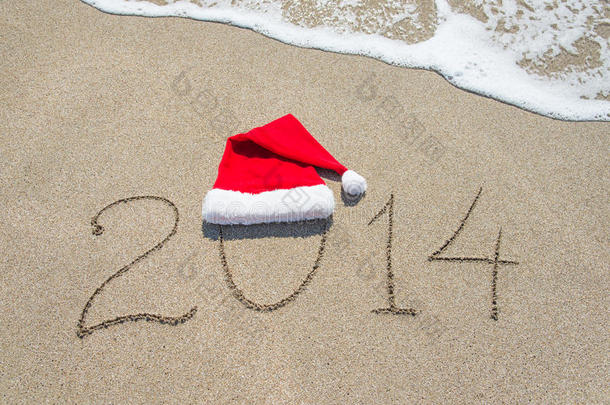 2014年新年快乐，海边沙滩上有圣诞帽，沙滩上有波浪