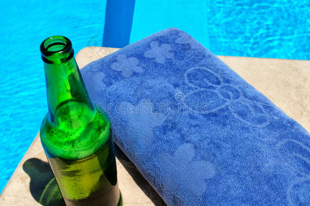 泳池边的啤酒和毛巾