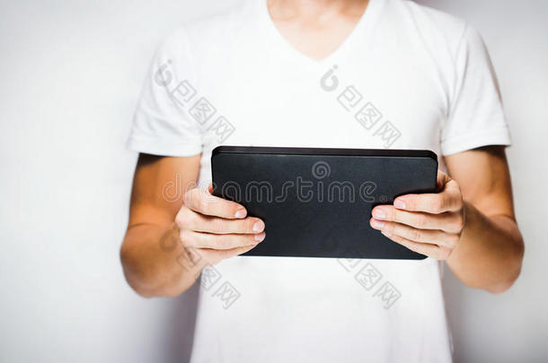 穿白色t恤的男士使用平板电脑