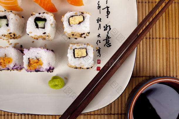 用<strong>筷子</strong>在<strong>盘子</strong>上的新鲜寿司和生鱼片