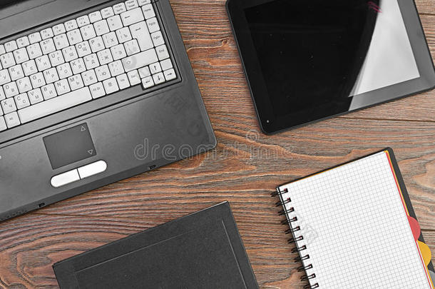木制桌子上的笔记本电脑和办公用品
